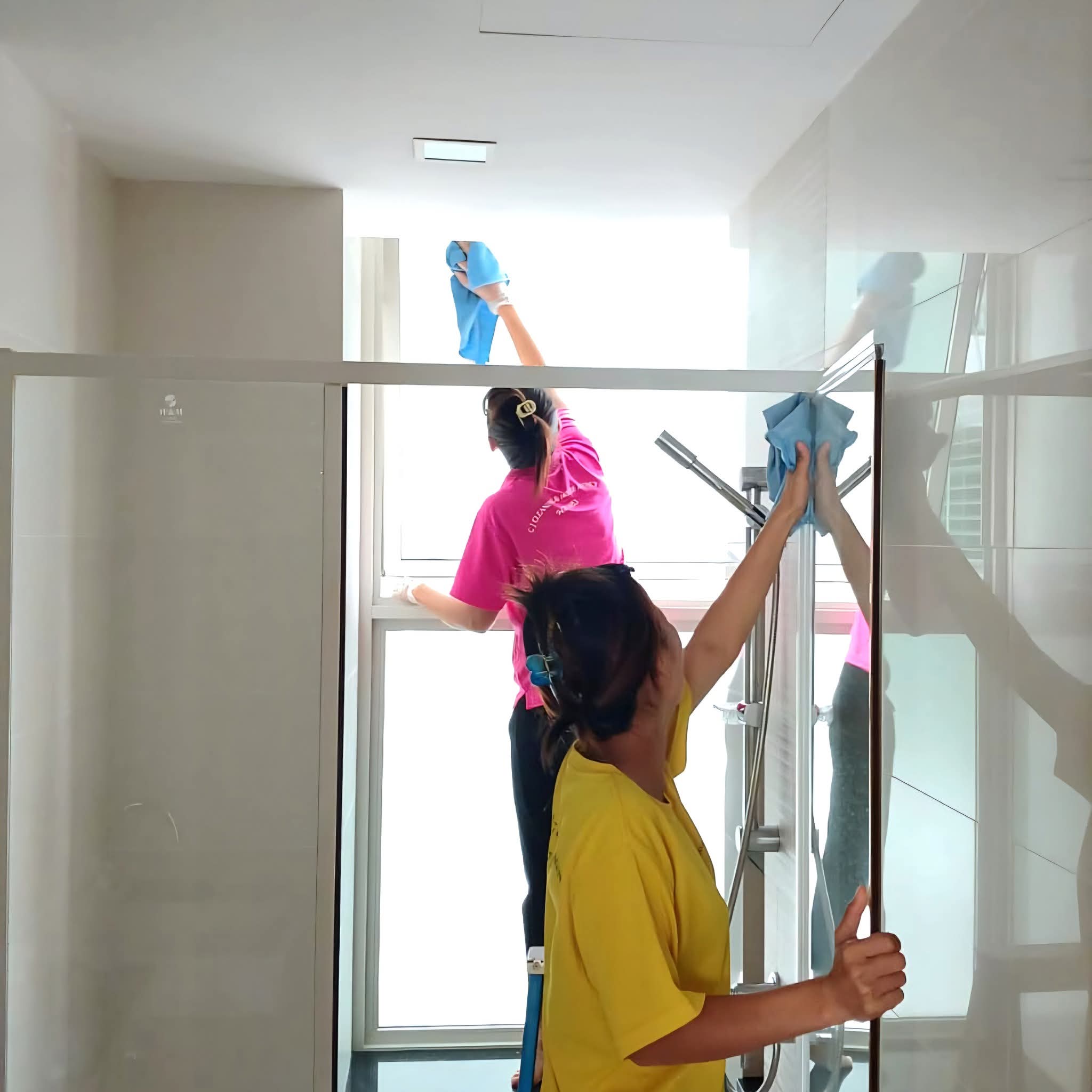 Avalon professional cleaners cleaning bathroom glass panels in Singapore home